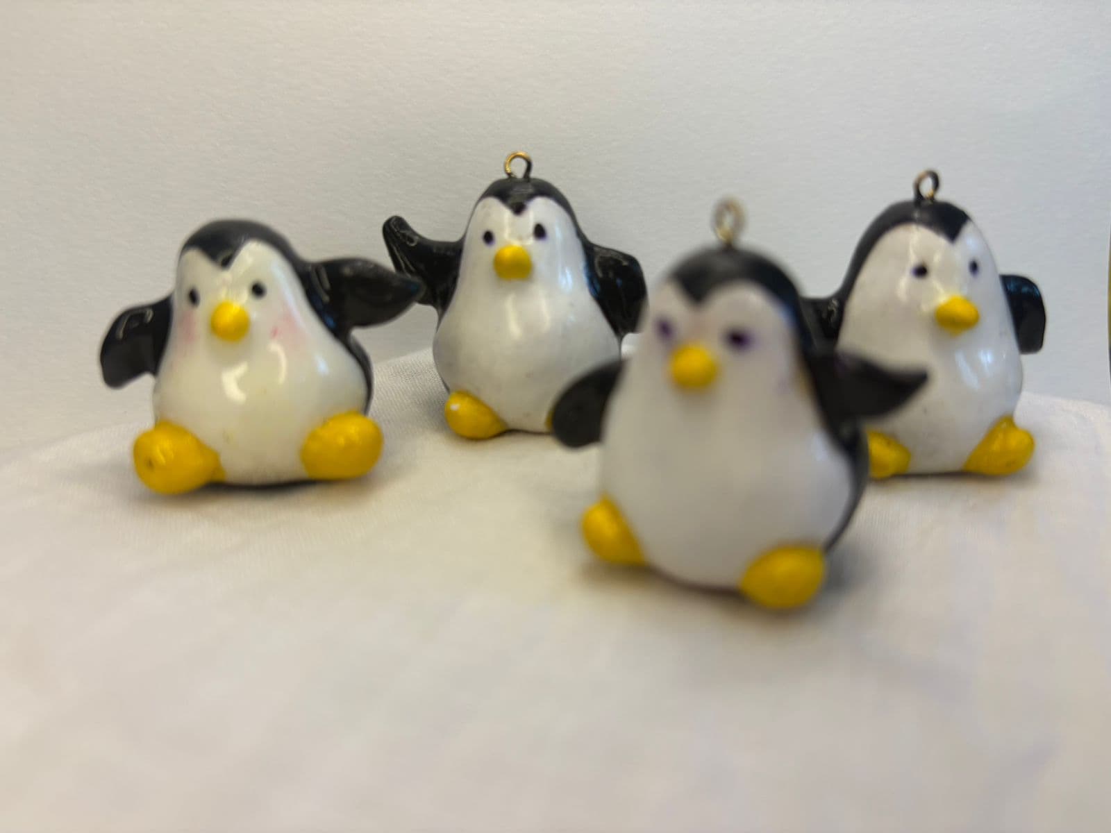 Handmade penguin miniatures on white fabric